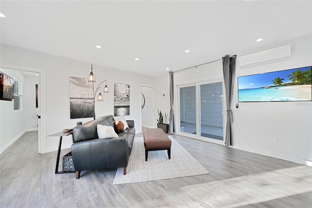 living room featuring an AC wall unit and light hardwood / wood-style flooring