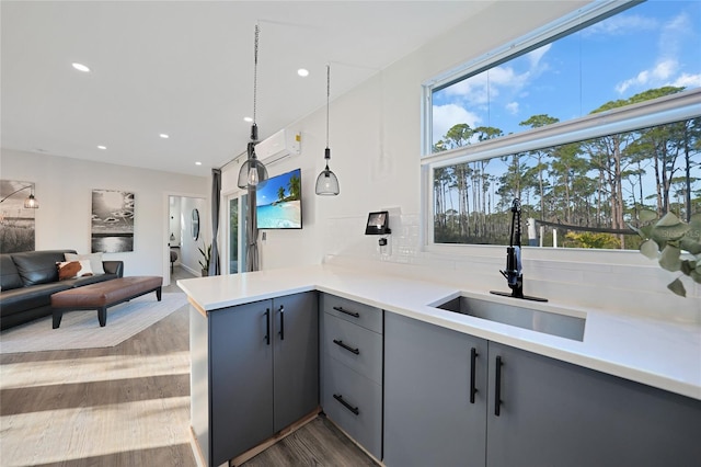 kitchen with decorative light fixtures, sink, decorative backsplash, kitchen peninsula, and dark wood-type flooring