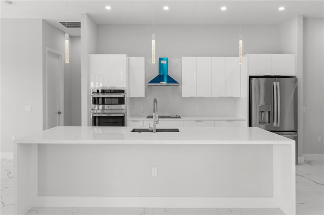 kitchen featuring stainless steel appliances, pendant lighting, wall chimney range hood, and modern cabinets