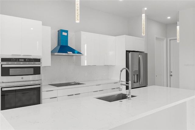 kitchen with hanging light fixtures, ventilation hood, modern cabinets, and appliances with stainless steel finishes