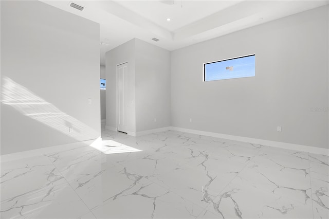 spare room with recessed lighting, visible vents, baseboards, marble finish floor, and a raised ceiling