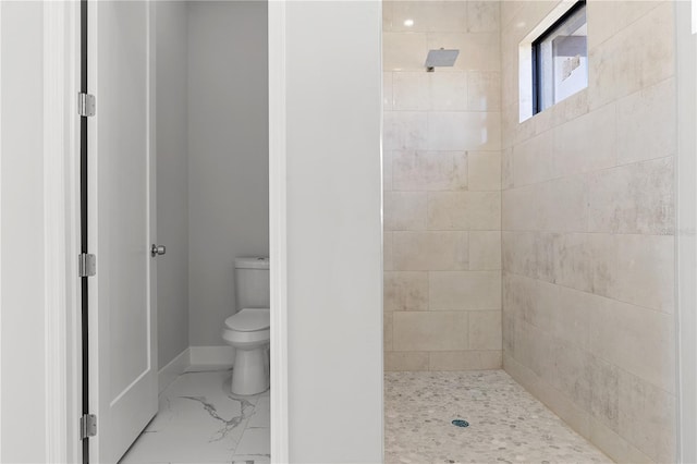 full bathroom with toilet, marble finish floor, baseboards, and tiled shower