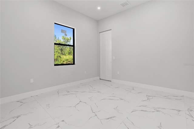 spare room featuring marble finish floor, baseboards, visible vents, and recessed lighting