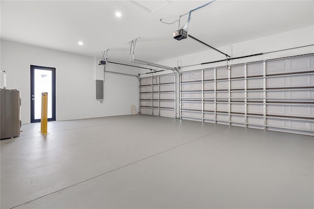 garage featuring water heater, recessed lighting, electric panel, and a garage door opener