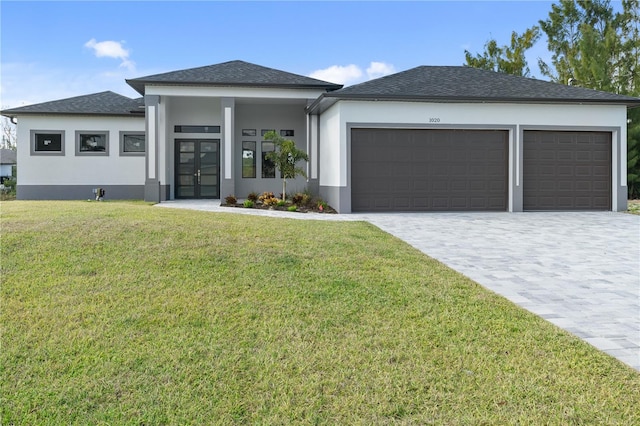 prairie-style home featuring a garage, a front lawn, decorative driveway, and stucco siding