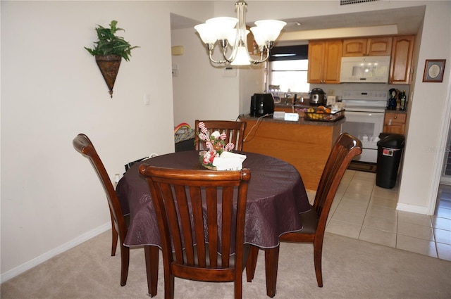 tiled dining area featuring sink and a notable chandelier