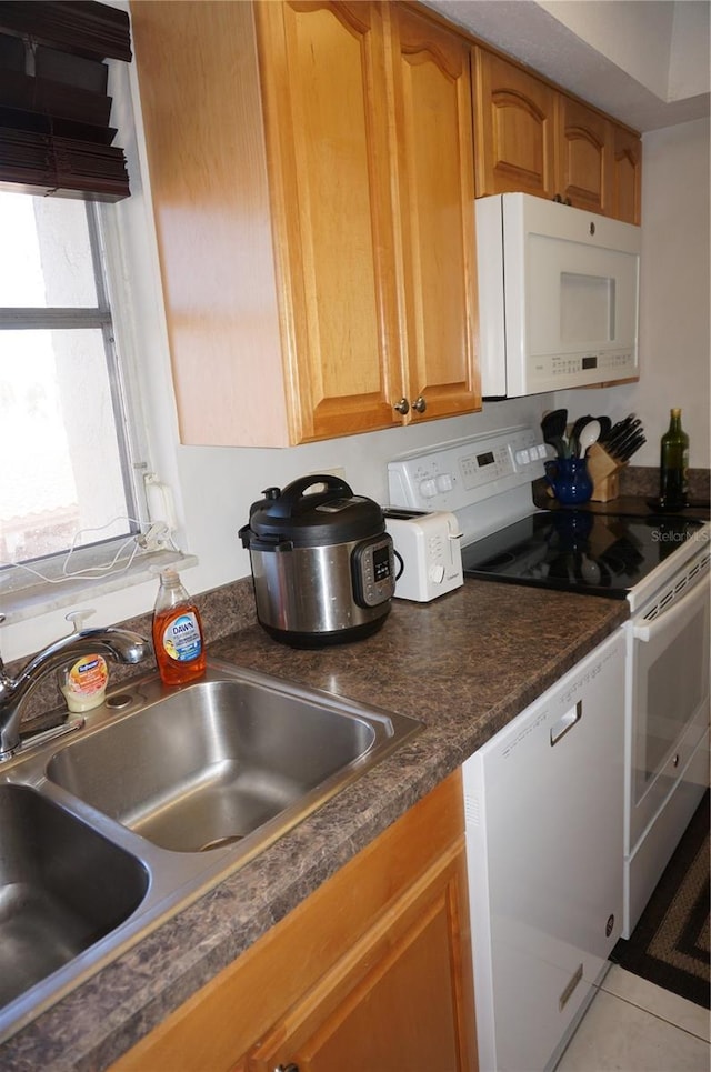 kitchen with sink, white appliances, and light tile patterned flooring