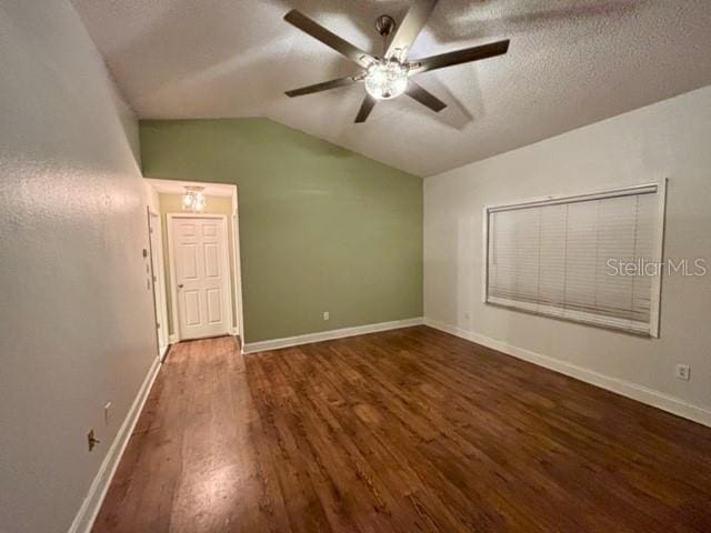 unfurnished room featuring ceiling fan, lofted ceiling, dark hardwood / wood-style floors, and a textured ceiling