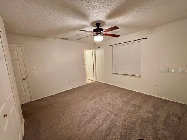 carpeted spare room with ceiling fan and a textured ceiling