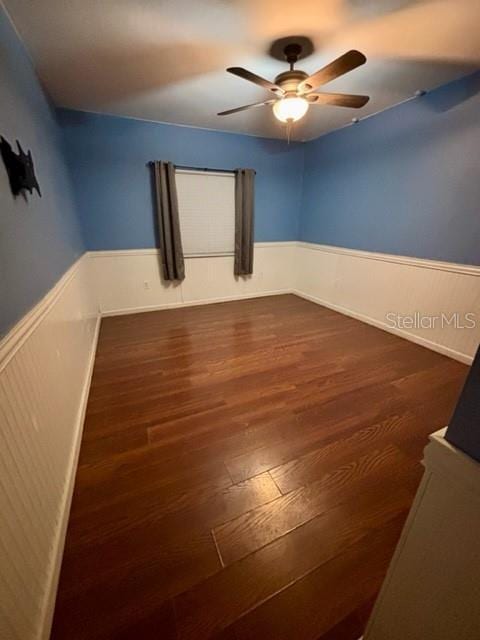 spare room with dark wood-type flooring and ceiling fan