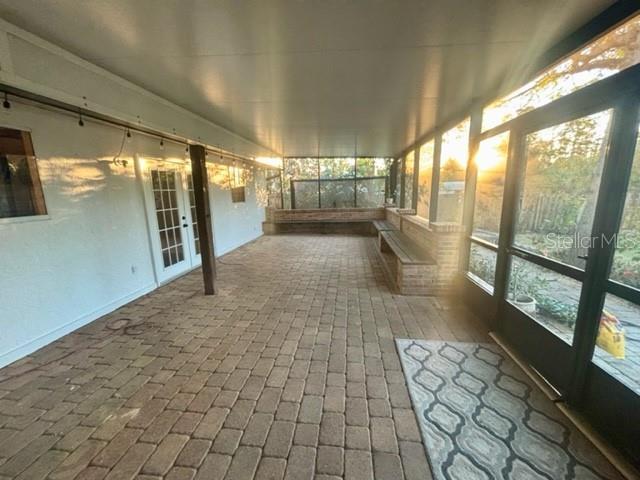unfurnished sunroom with french doors and brick floor