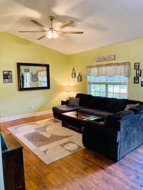 18085 Wintergarden Ave, Port Charlotte, FL 33948 - living area featuring wood finished floors, ceiling fan, and lofted ceiling