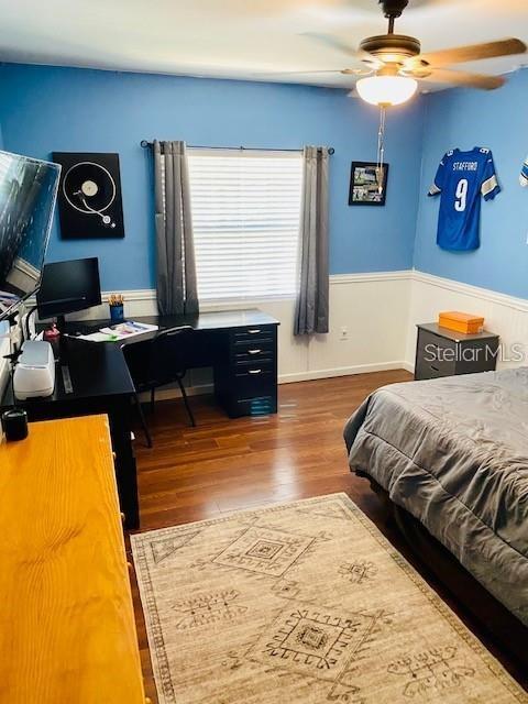 18085 Wintergarden Ave, Port Charlotte, FL 33948 - bedroom with a desk, wood finished floors, wainscoting, and ceiling fan