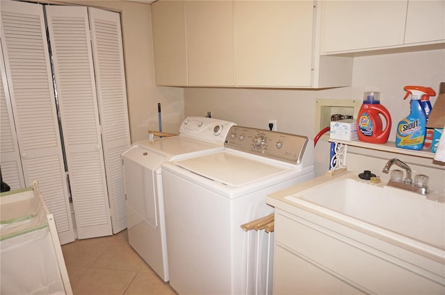 laundry room featuring light tile patterned floors, washer and clothes dryer, cabinets, and sink