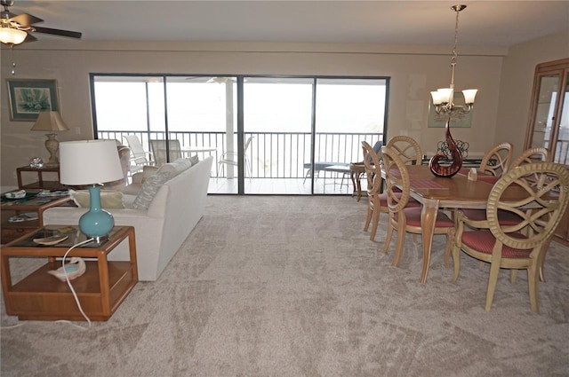 carpeted dining area with ceiling fan with notable chandelier