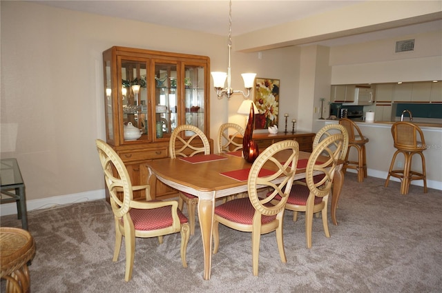 dining space with an inviting chandelier and carpet floors