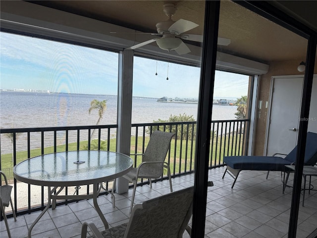 balcony featuring a water view and ceiling fan