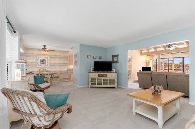 carpeted living room featuring wooden walls and ceiling fan