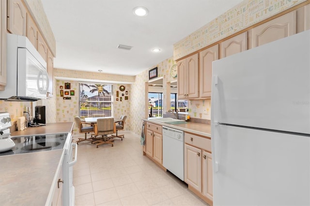 kitchen featuring sink, light brown cabinets, and white appliances