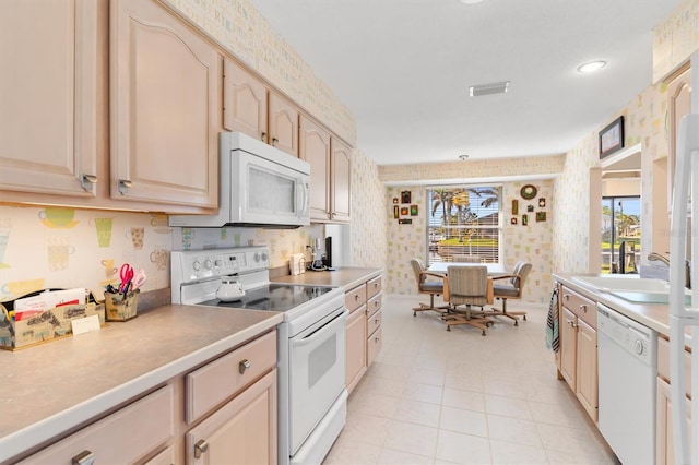 kitchen with light brown cabinetry, decorative light fixtures, sink, light tile patterned floors, and white appliances