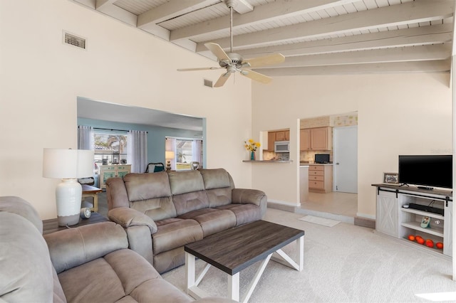 living room with ceiling fan, beam ceiling, high vaulted ceiling, and light carpet