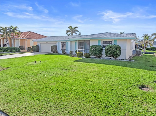 ranch-style house featuring a garage, central AC unit, and a front lawn