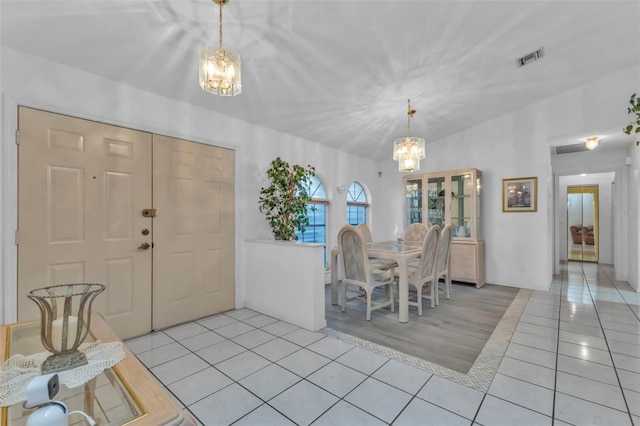 dining space with a notable chandelier and light tile patterned flooring