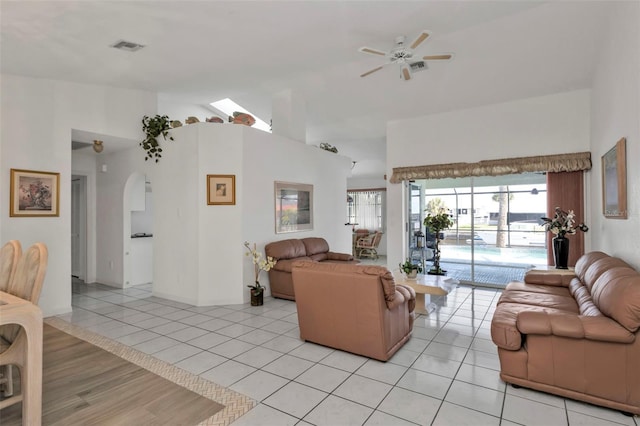 living room with ceiling fan, lofted ceiling, and light tile patterned floors