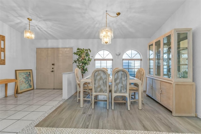 dining area featuring light tile patterned flooring and a notable chandelier