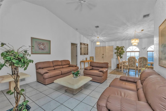 tiled living room featuring ceiling fan with notable chandelier and vaulted ceiling