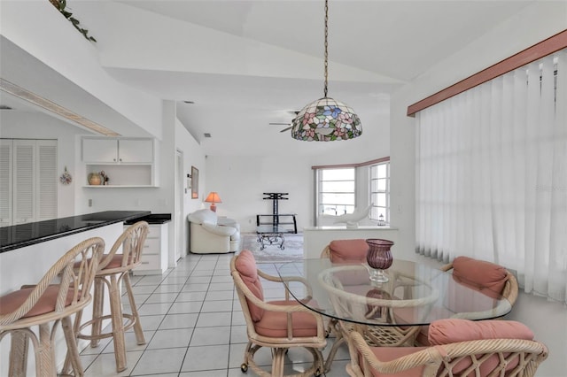 tiled dining area with vaulted ceiling