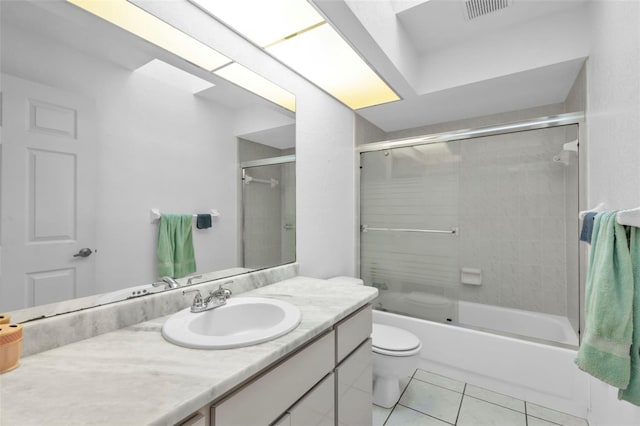 full bathroom featuring tile patterned flooring, vanity, bath / shower combo with glass door, and toilet