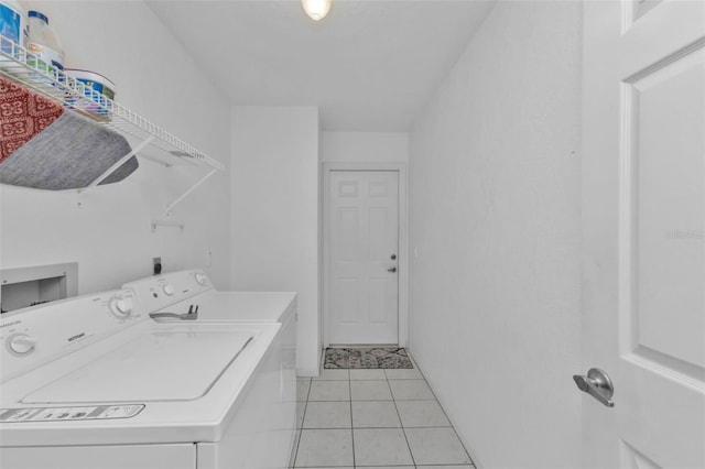 laundry area featuring washer and dryer and light tile patterned floors