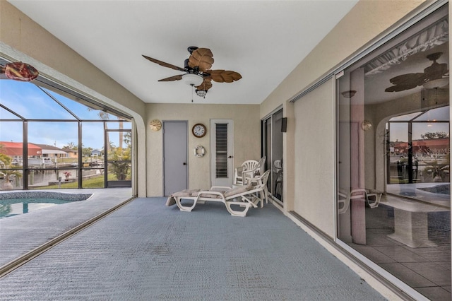 unfurnished sunroom featuring ceiling fan