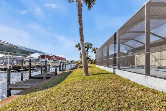 view of yard featuring a water view, a boat dock, and glass enclosure