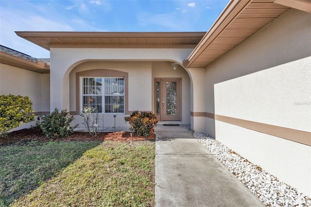 doorway to property with a lawn