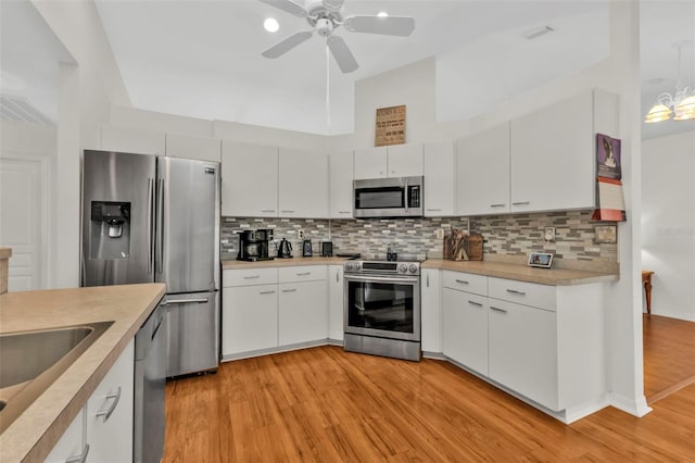 kitchen featuring ceiling fan, appliances with stainless steel finishes, white cabinetry, backsplash, and light hardwood / wood-style floors