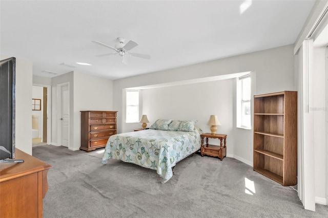 bedroom featuring connected bathroom, light colored carpet, and ceiling fan