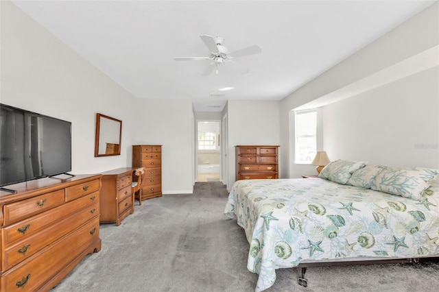 carpeted bedroom with ensuite bathroom and ceiling fan