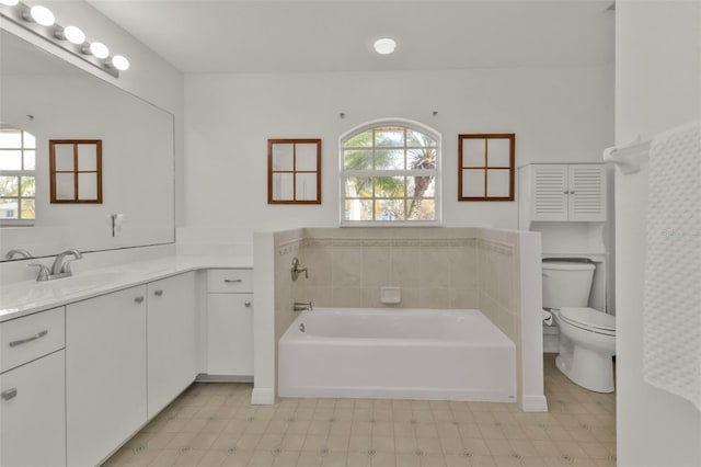 bathroom with vanity, a bath, and toilet