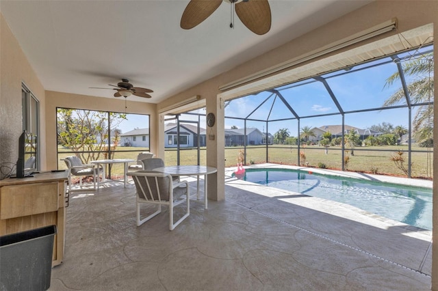 view of swimming pool with ceiling fan, an outdoor bar, and a patio area