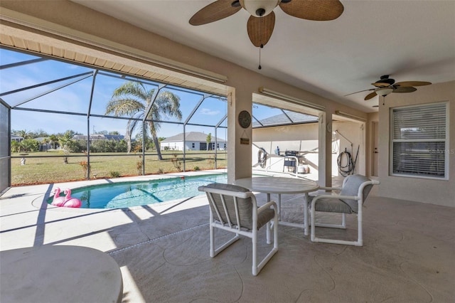 view of pool with ceiling fan, a patio, and glass enclosure