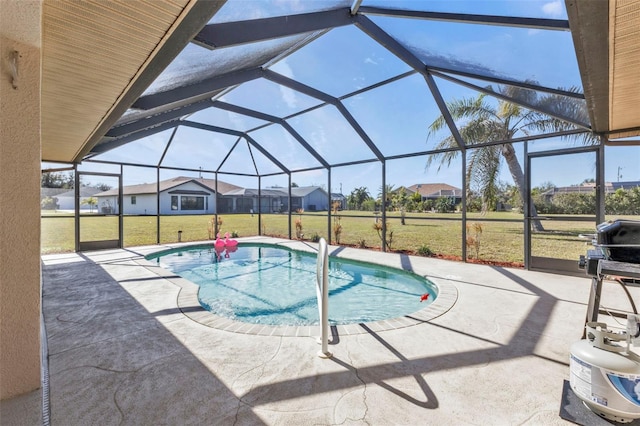 view of swimming pool featuring a lanai, a yard, and a patio area