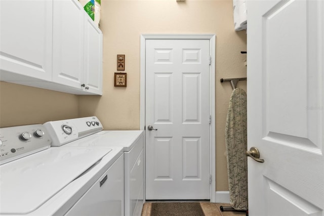 laundry area with cabinets, tile patterned flooring, and washing machine and dryer