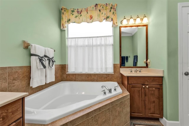 bathroom featuring tiled tub and vanity