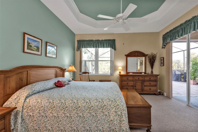 bedroom with ceiling fan, a raised ceiling, carpet floors, and access to outside