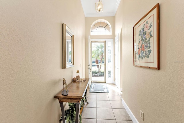 doorway to outside with light tile patterned floors and ornamental molding