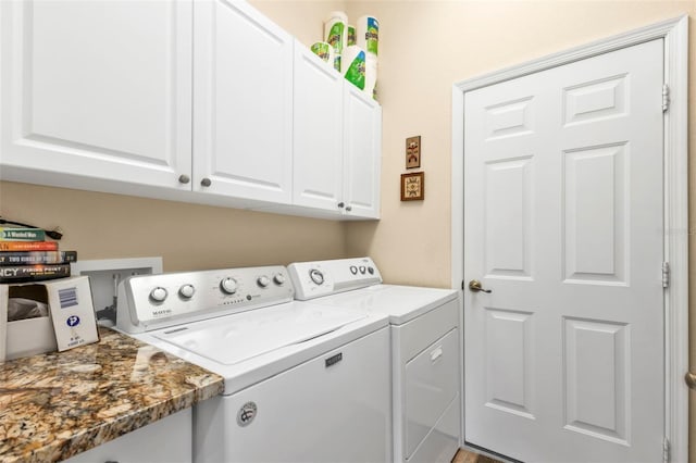 clothes washing area with washer and clothes dryer and cabinets