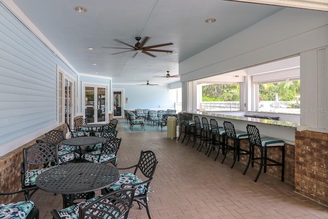 view of patio featuring ceiling fan and exterior bar