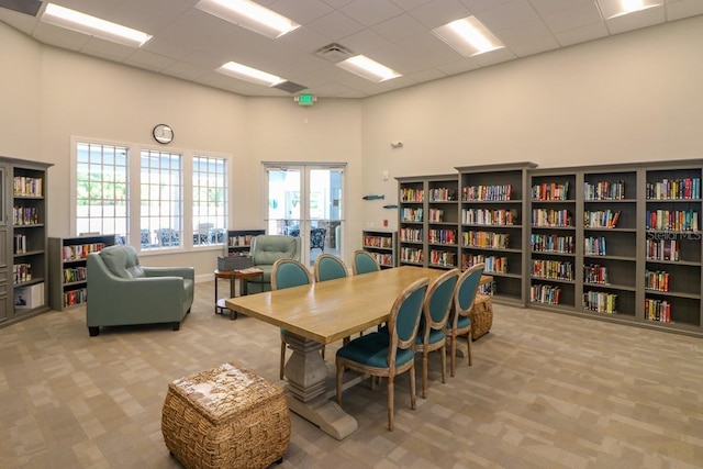 carpeted office space with a towering ceiling and a drop ceiling